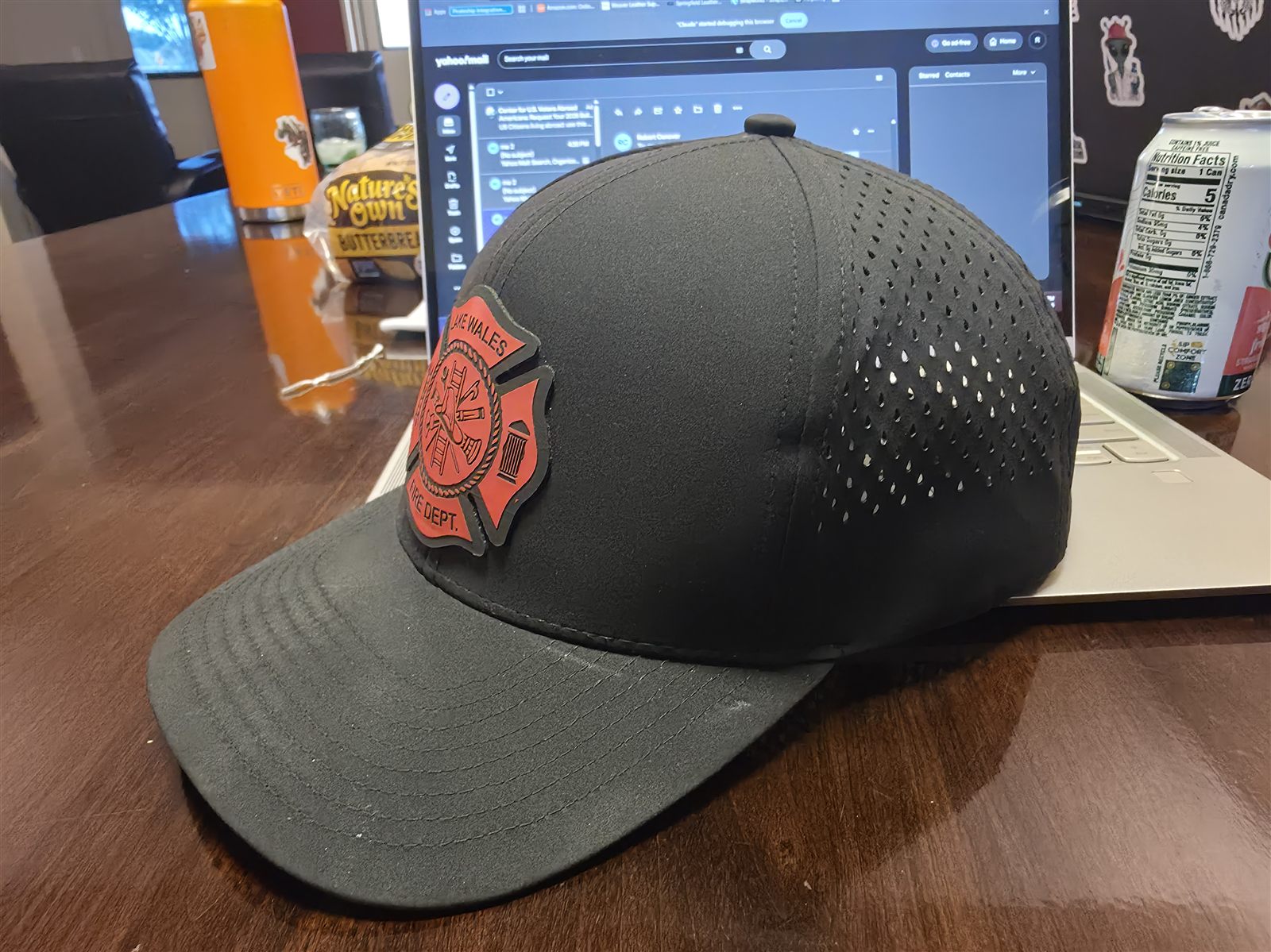 Side view of black waterproof performance hat showing laser perforated panels and leather fire department patch