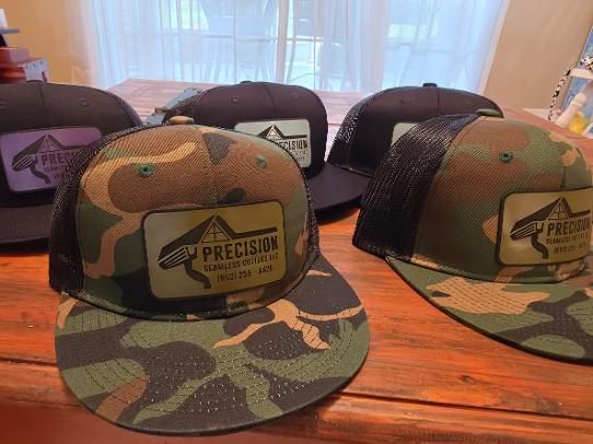 Camo and black trucker hats with custom company leather patches